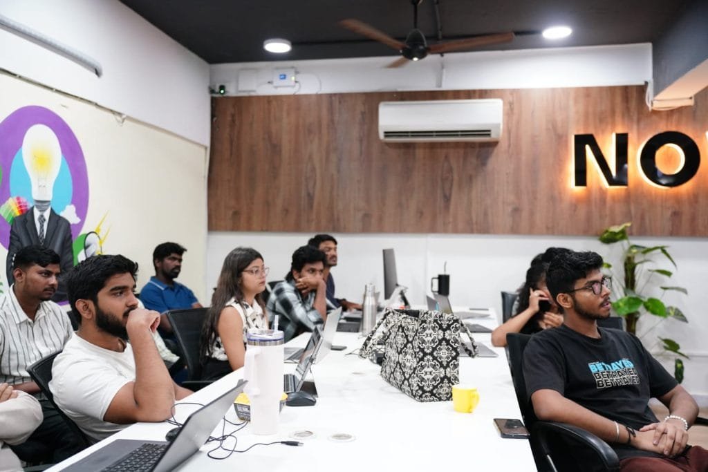 Team meeting at Digital Mojo Hyderabad office with professionals collaborating around conference table with laptops