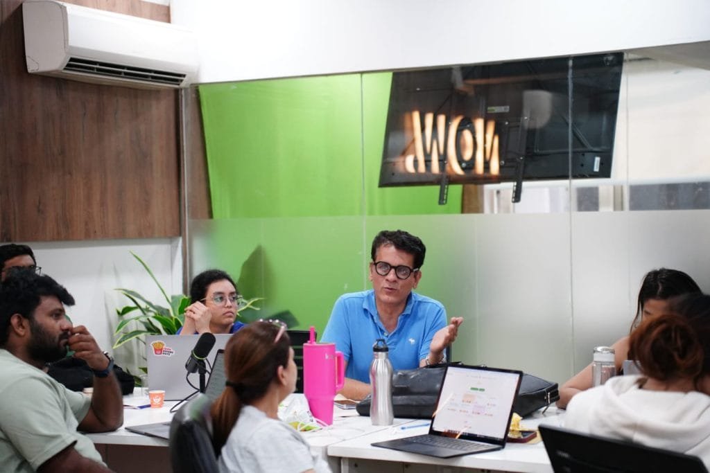 Professional team meeting at Digital Mojo Hyderabad office with employees discussing marketing strategy around conference table