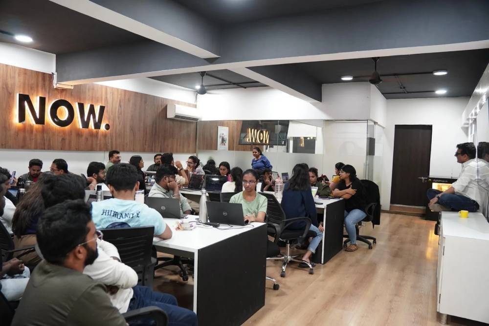 Digital marketing team collaborating in modern office space with NOW branding at Digital Mojo Hyderabad