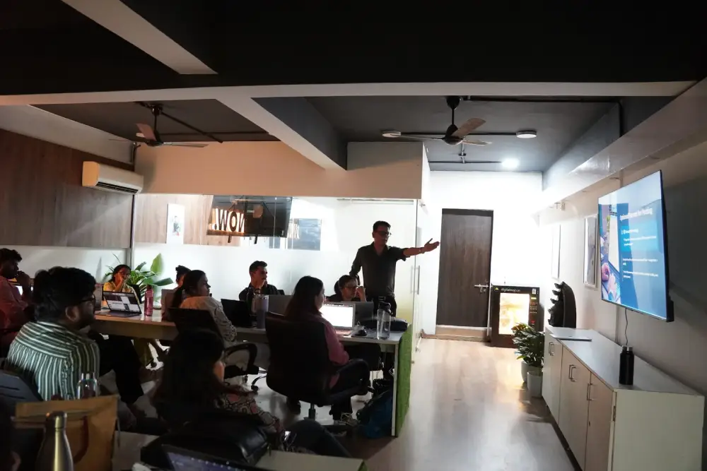 Digital marketing team meeting in modern office with presenter discussing strategy on screen