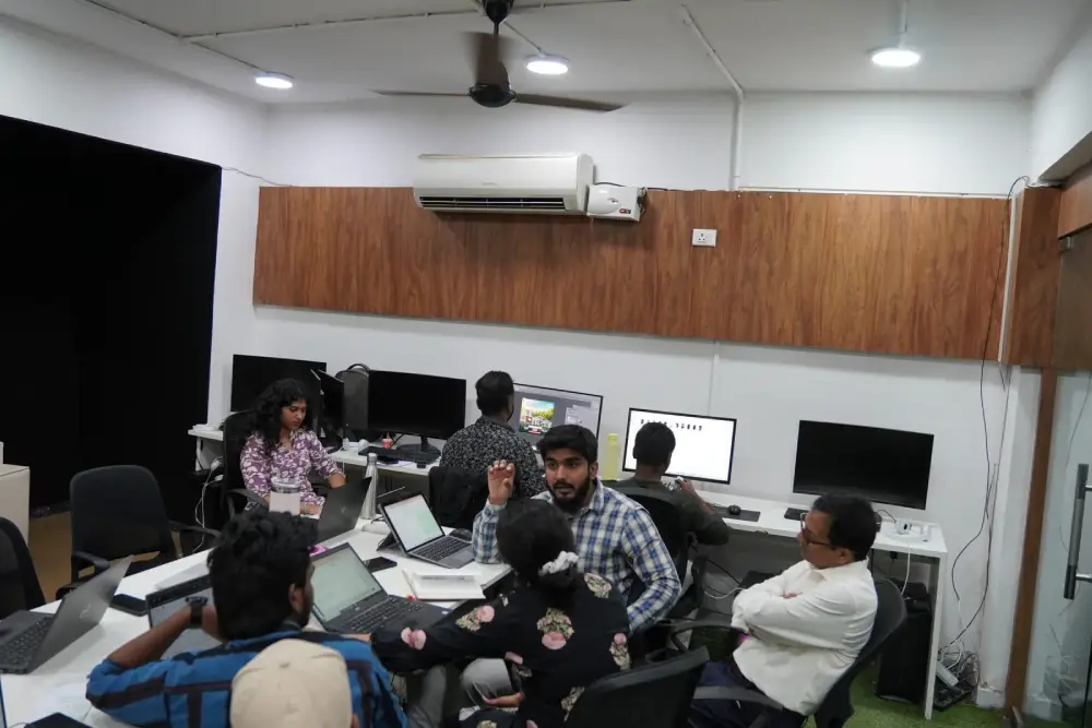 Digital marketing team collaborating in modern office workspace with computers and laptops
