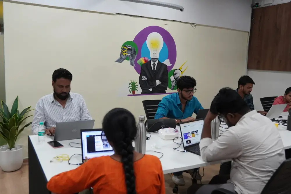 Team collaboration at Digital Mojo Hyderabad office with creative professionals working on laptops and digital projects
