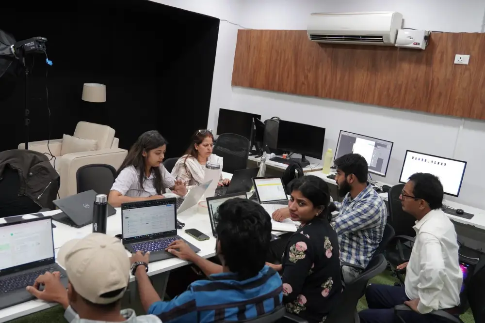 Digital marketing team collaborating in modern office with laptops and computers during brainstorming session
