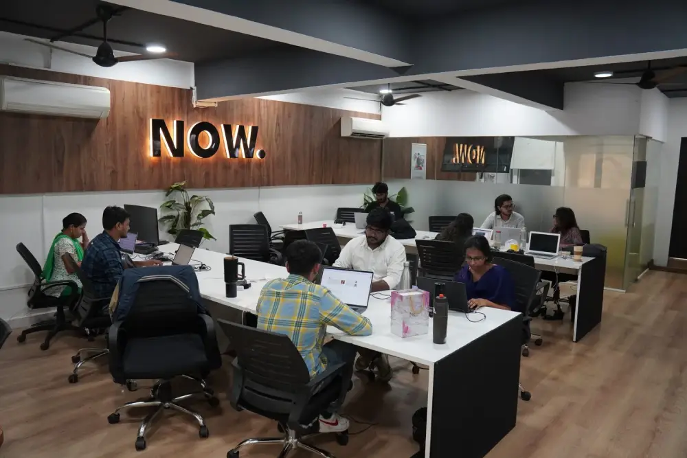 Modern office workspace at Digital Mojo Hyderabad with collaborative team members working at desks with laptops