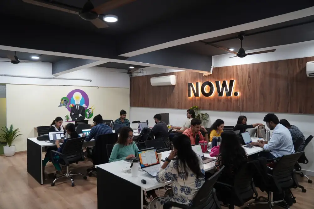 Digital marketing team collaborating in modern office space with laptops and creative workspace