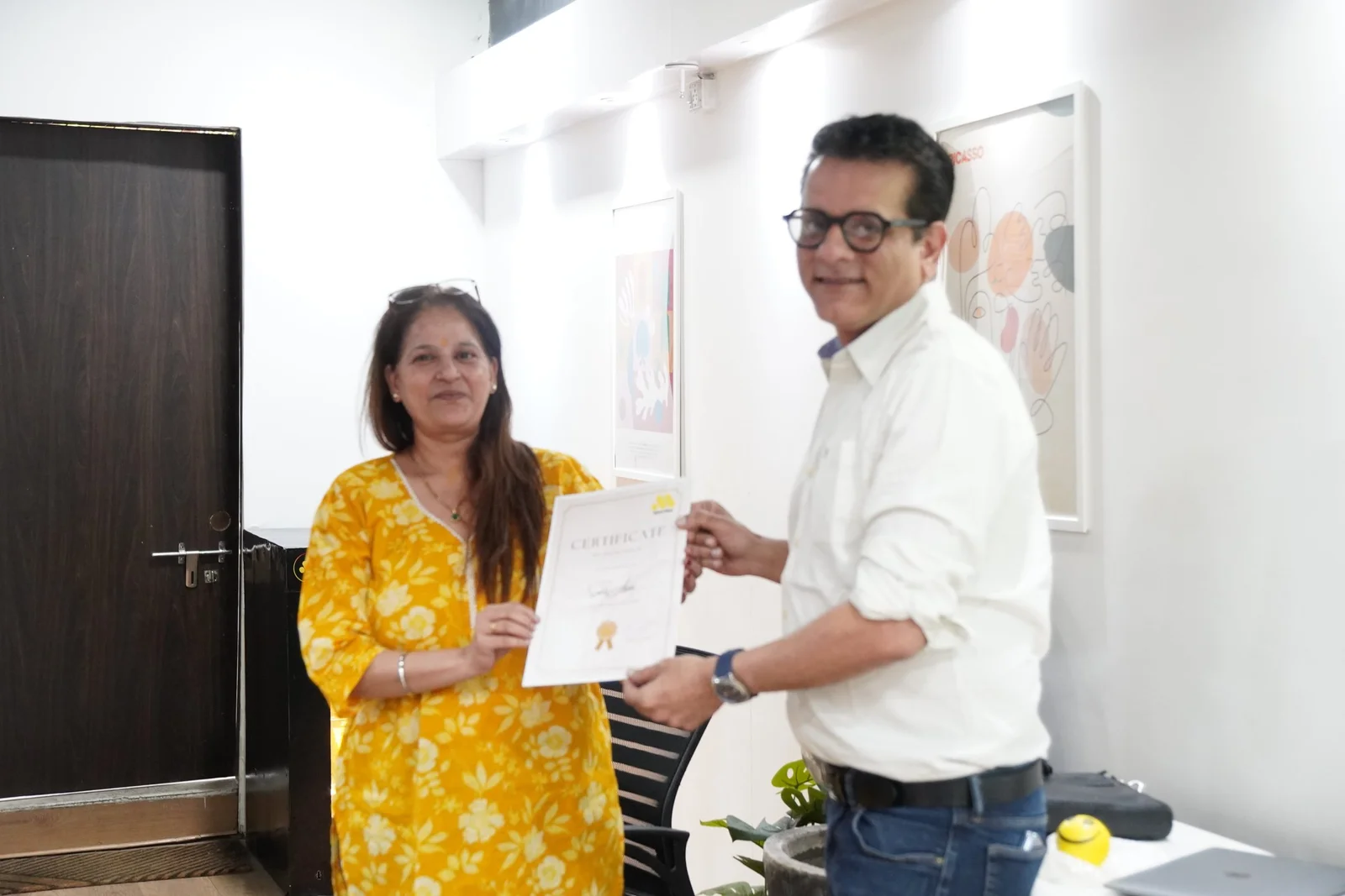 Professional woman receiving certificate from man in office setting at Digital Mojo Hyderabad
