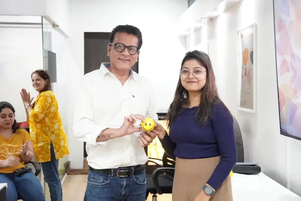 Team members at Digital Mojo Hyderabad celebrating with smiley face badge in modern office
